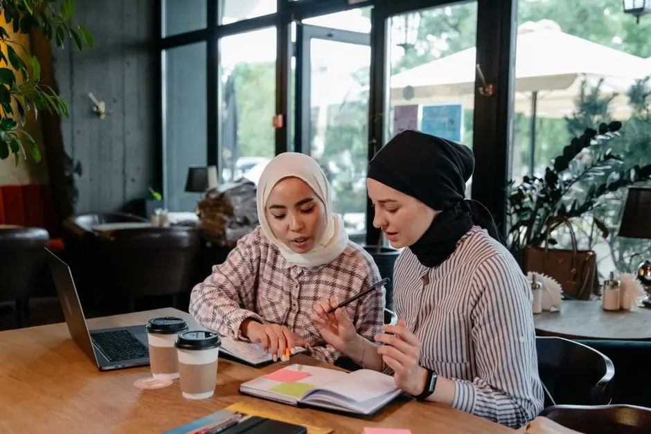 Sekelompok wanita duduk melingkar di ruang tamu sambil berdiskusi dengan notebook dan secangkir kopi